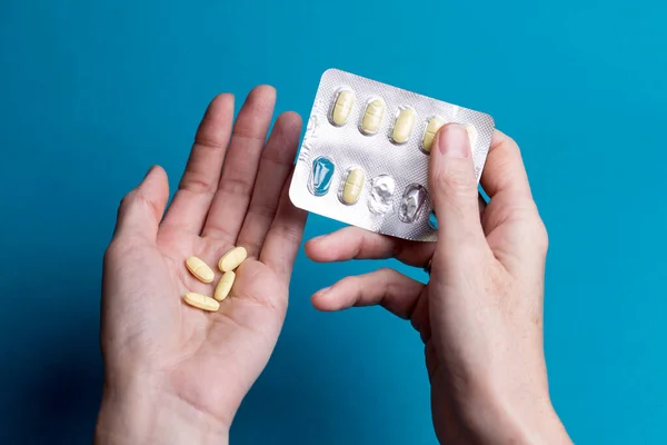 Frau Gießt Tabletten Von Einer Hand Zur Anderen — Stockfoto