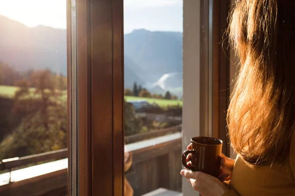 Menina Segurando Uma Xícara Café Olha Pela Janela Montanhas Backgroun — Fotografia de Stock