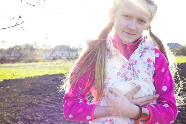 太陽の下の庭の芝生の上の女の子とウサギ — ストック写真