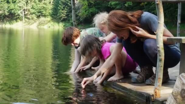 Niños Sentados Orilla Lago Con Los Pies Agua — Vídeo de stock