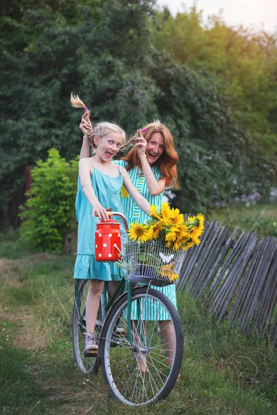 ひまわりのバスケットと古い自転車の中でクレイジー幸せな女の子 レトロなスタイル 村の夏だ お母さんと娘 — ストック写真