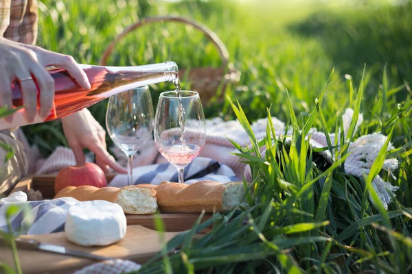 草原上的普罗旺斯野餐 女孩在野餐篮边的杯子里倒酒 — 图库照片