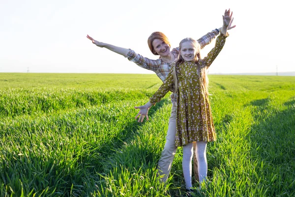 幸せな母親と娘が太陽の下で畑で — ストック写真
