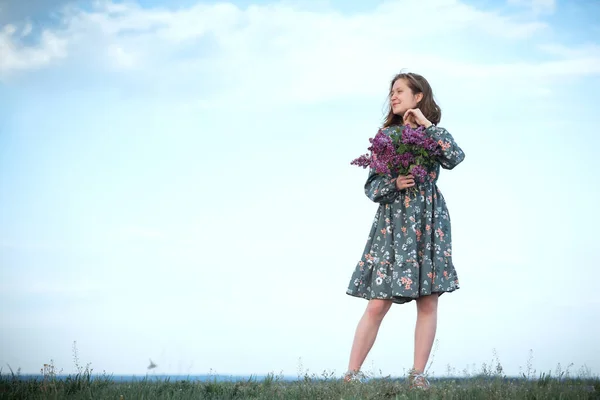 美しいです幸せな女の子とともにライラックの花束屋外でリスクに対して — ストック写真