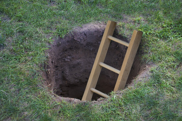 Ladder coming out of a hole in the ground 