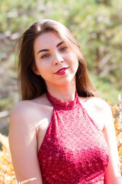 Orman arka planında kırmızı elbiseli genç kız.