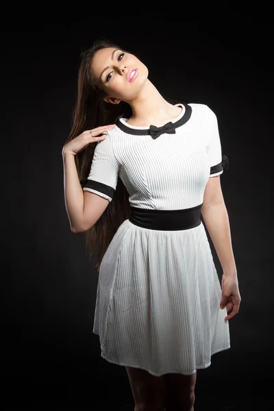 Beautiful young girl in a white dress on a black background. Studio portrait. — Stock Photo, Image