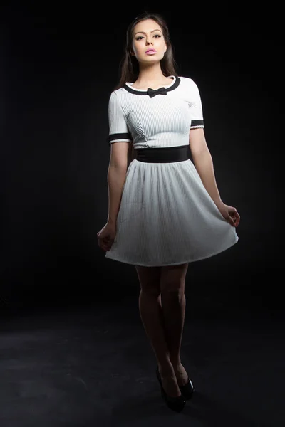Menina bonita em um vestido branco em um fundo preto. Retrato de estúdio . — Fotografia de Stock