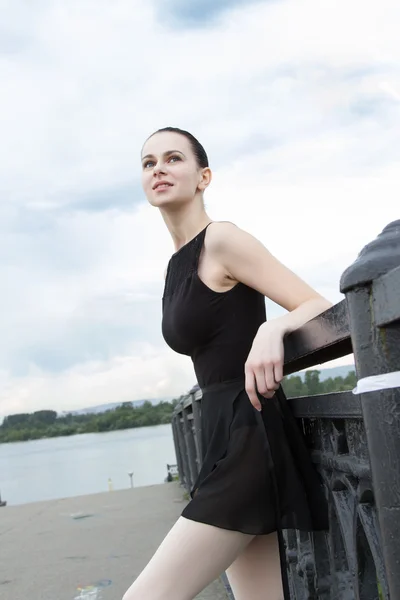 Slanke danseres staande op de ijzeren balustrades van de brug — Stockfoto