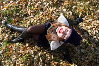 Sonbahar Park sarı yapraklar üzerinde oturan genç kız