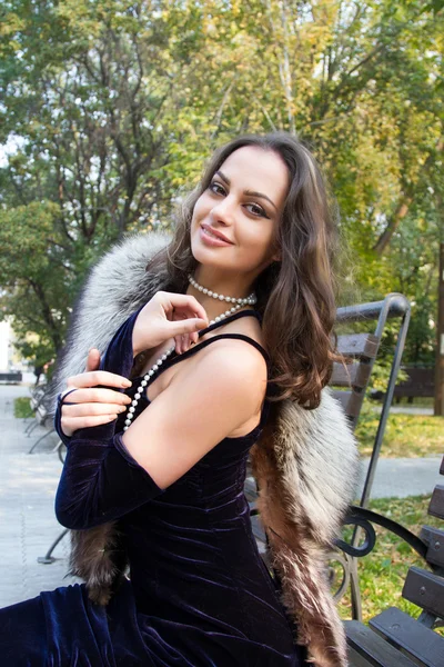 Kız sonbahar parkta bir bankta oturuyor