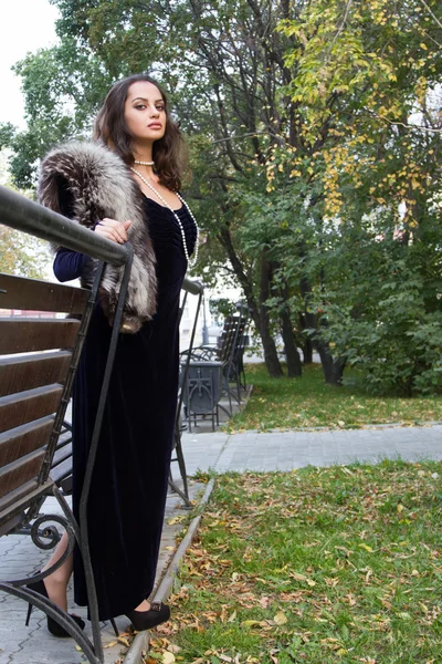 Girl in evening dress walks on autumn park — Stockfoto
