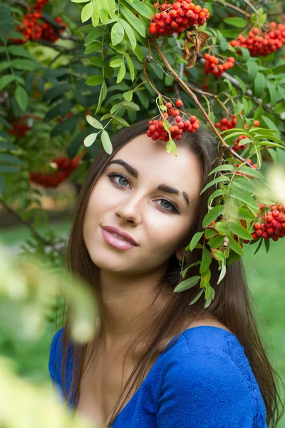 Portrait of a young girl among the bunches of rowan — Stock Photo, Image