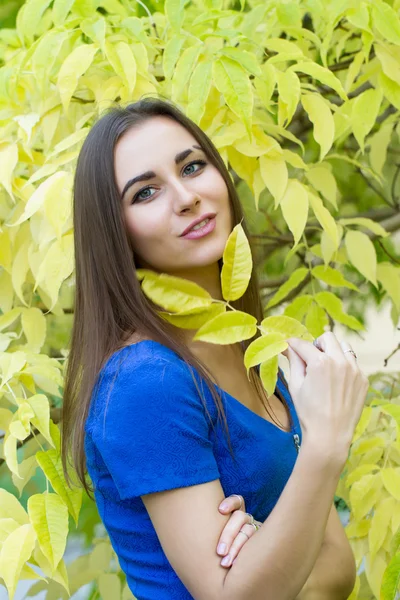 Junges Mädchen auf einem Hintergrund aus gelben Herbstblättern — Stockfoto