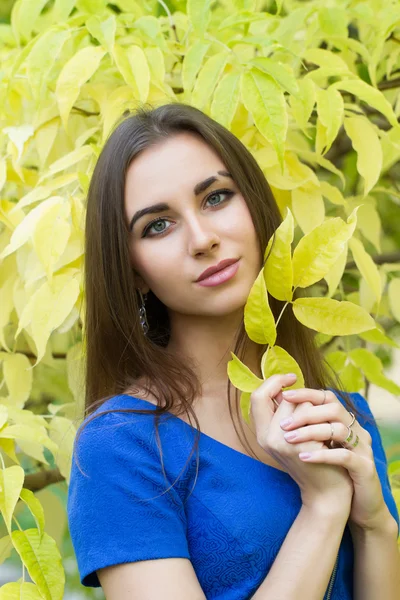 Jeune fille sur un fond de feuilles d'automne jaunes — Photo