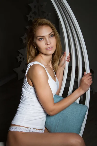 Rubia en ropa interior blanca sentado en un columpio —  Fotos de Stock