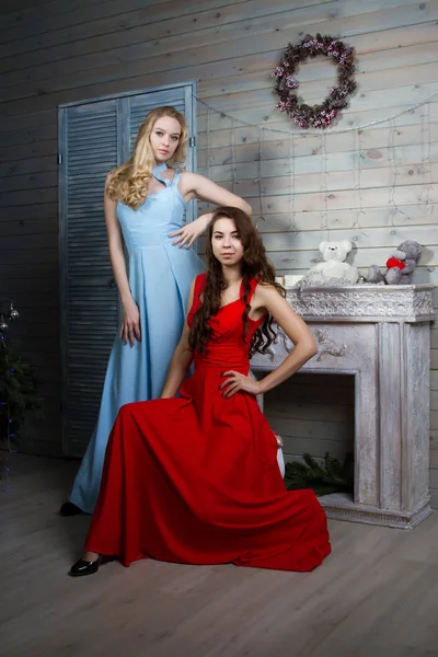 Zwei junge Mädchen in langen Kleidern in einem Raum mit Kamin — Stockfoto