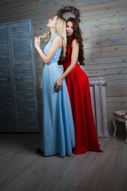 Uzun elbiseler şömineli bir odada iki genç genç kız