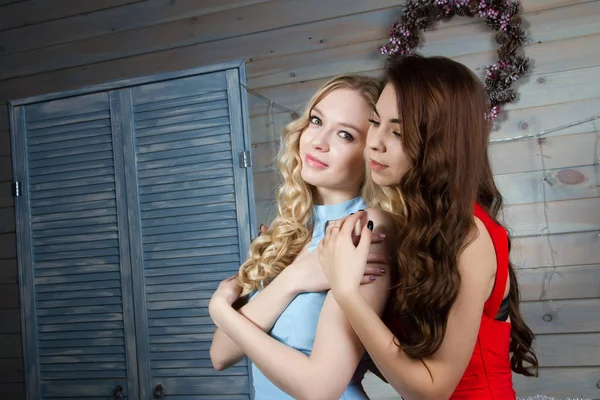 Two girls in evening gowns in the room with fireplace — Stock Photo, Image