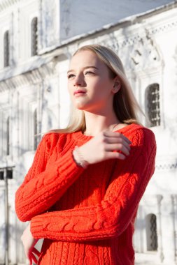 Kilise bir arka plan üzerinde kırmızı bir kazak sarışın