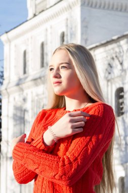 Kilise bir arka plan üzerinde kırmızı bir kazak sarışın