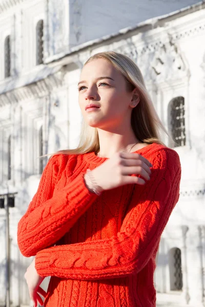 Kilise bir arka plan üzerinde kırmızı bir kazak sarışın