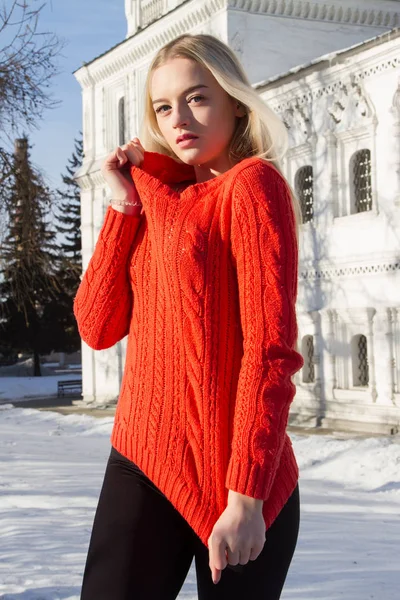Blondine im roten Pullover vor dem Hintergrund der Kirche — Stockfoto