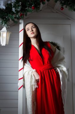 Evin verandada kırmızı akşam elbiseli kız