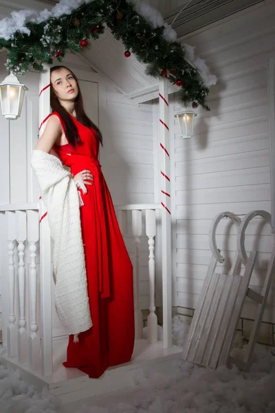 Дівчина в червоній вечірній сукні на ганку будинку — стокове фото