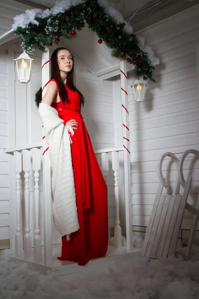 Evin verandada kırmızı akşam elbiseli kız