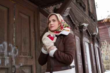 Eski bir ahşap ev bir arka plan üzerinde kırmızı elma ile kız