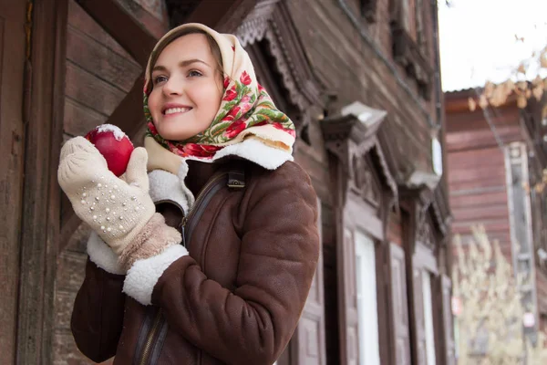 Eski bir ahşap ev bir arka plan üzerinde kırmızı elma ile kız