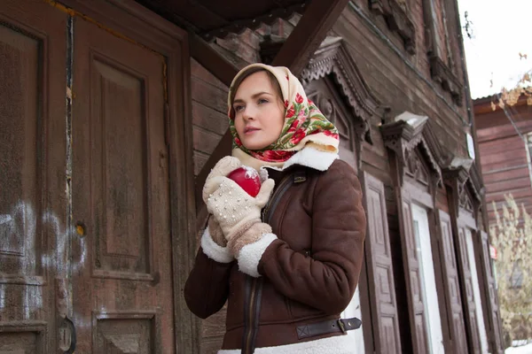 Eski bir ahşap ev bir arka plan üzerinde kırmızı elma ile kız