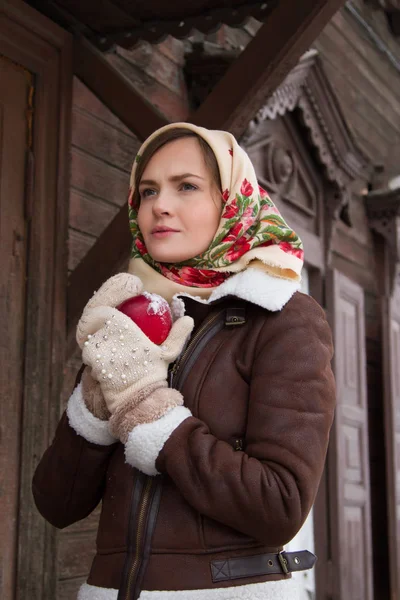 Eski bir ahşap ev bir arka plan üzerinde kırmızı elma ile kız