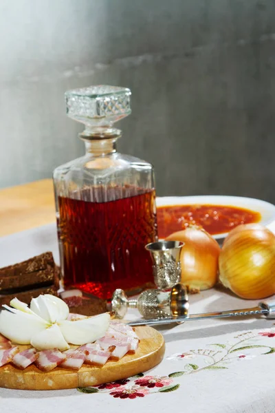 Caraffa con tintura di alcol, con stand snack sul tavolo — Foto Stock
