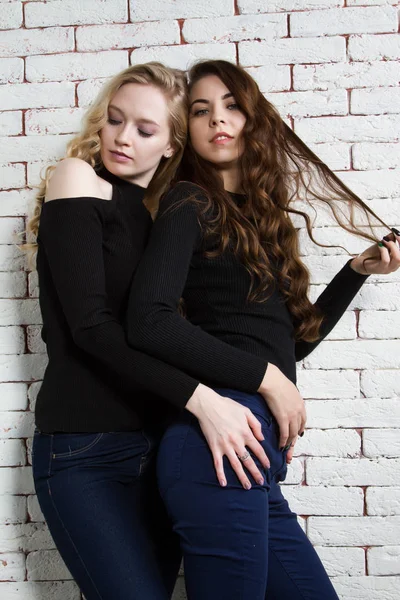 Blonde and brunette hugging each other — Stock Photo, Image