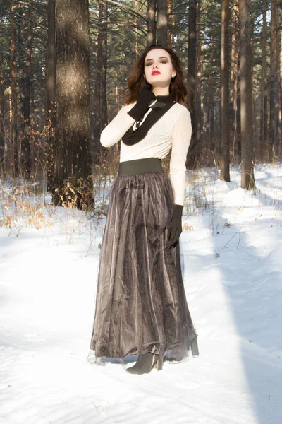 Девушка в длинной юбке в зимнем лесу — стоковое фото