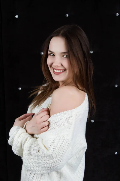 Retrato de una chica emocional en un suéter blanco sobre un fondo negro. Retrato de estudio —  Fotos de Stock