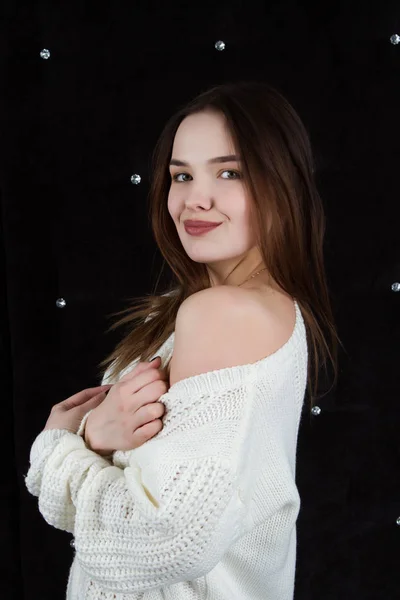 Retrato de uma menina emocional em uma camisola branca em um fundo preto. Retrato de estúdio — Fotografia de Stock