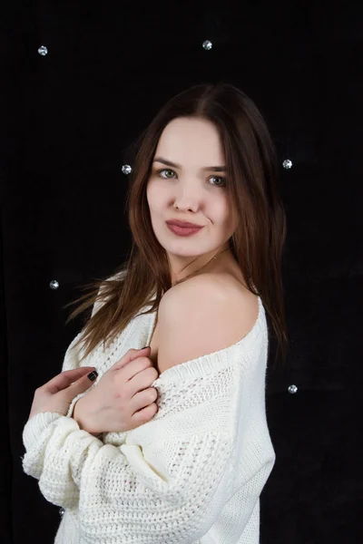 Retrato de una chica emocional en un suéter blanco sobre un fondo negro. Retrato de estudio —  Fotos de Stock