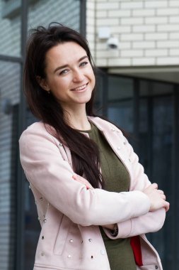 Genç iş kadını arka planda bir ofis binası