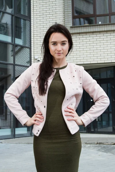 Jonge zakenvrouw op de achtergrond van een kantoorgebouw — Stockfoto