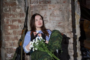 Bir buket çiçek ile yıkıntıları üzerinde kız keskin nişancı