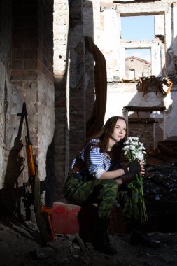 Bir buket çiçek ile yıkıntıları üzerinde kız keskin nişancı
