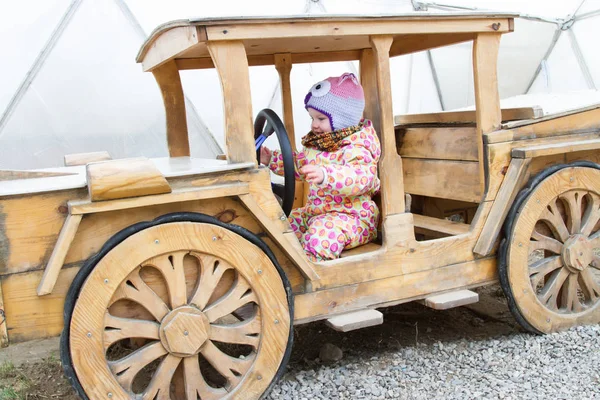 Счастливый ребенок за рулем деревянного автомобиля — стоковое фото