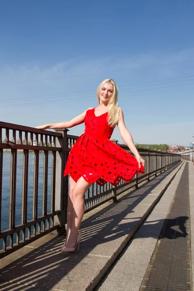 Blonde in een korte zomerjurk aan de oever van de rivier van de Angara in Irkoetsk — Stockfoto