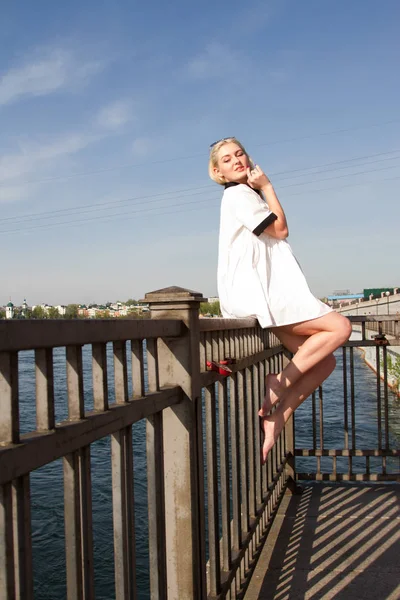 Young girl on the river embankment in white dress — Stock Photo, Image