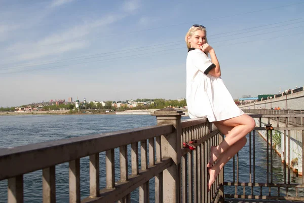 Jeune fille sur le remblai de la rivière en robe blanche — Photo