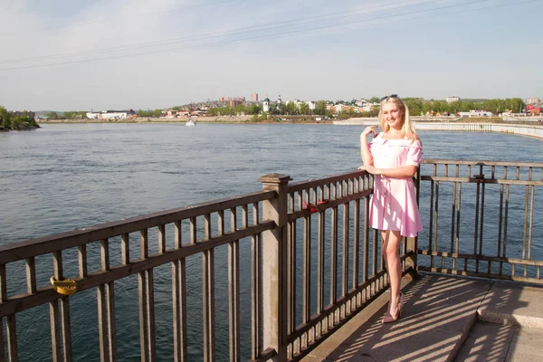 Jeune fille sur le remblai de la rivière dans une robe rose courte — Photo