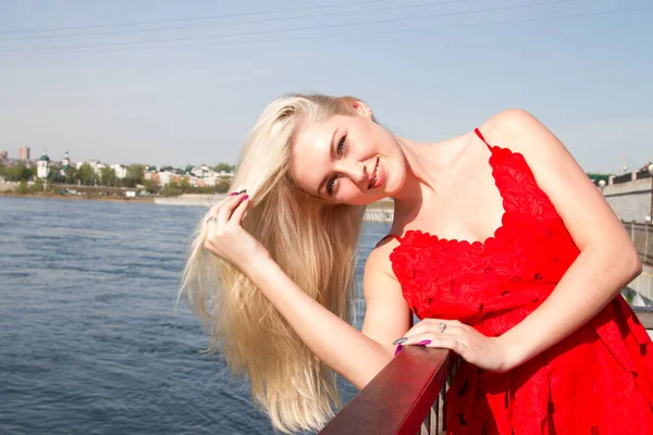 Junges Mädchen im kurzen roten Kleid am Flussufer — Stockfoto